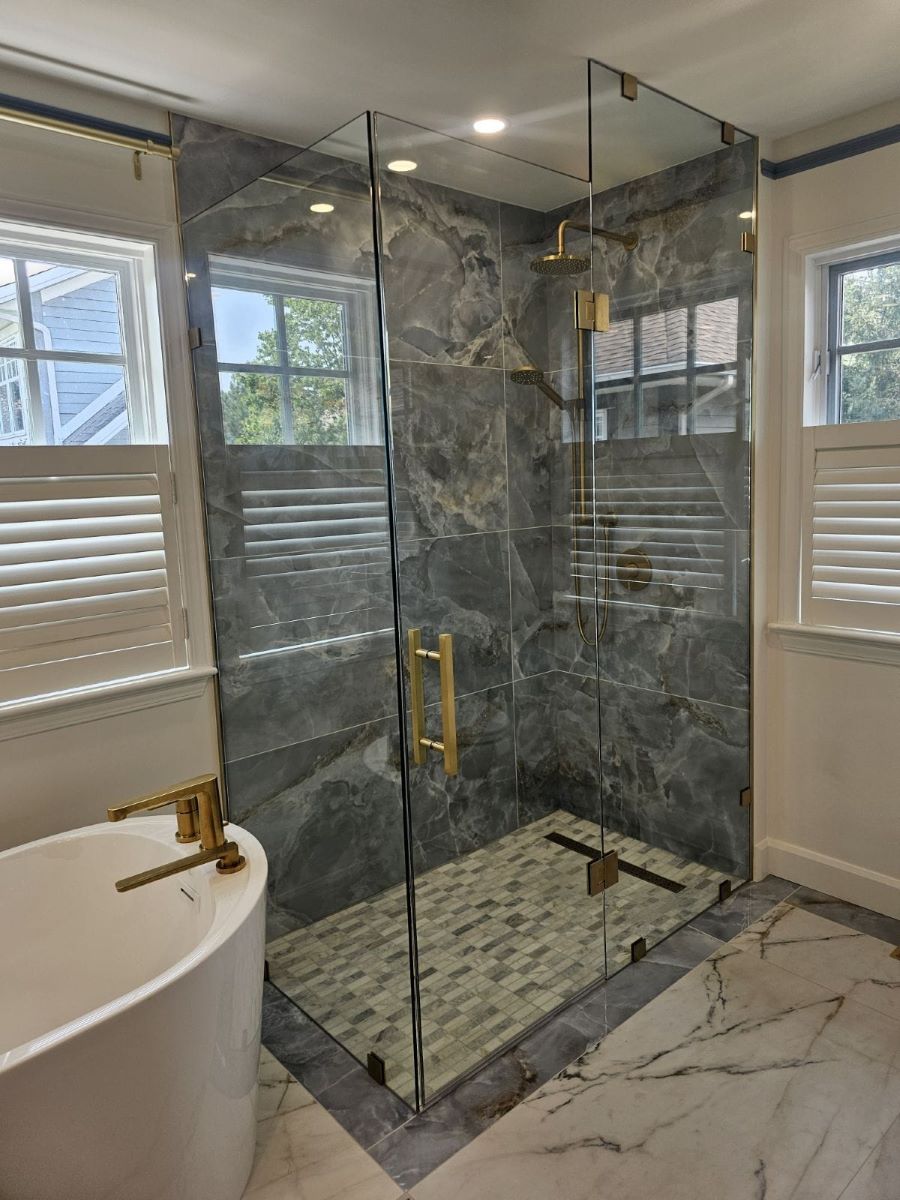 custom frameless glass shower with satin brass clamps and square ladder pull handle