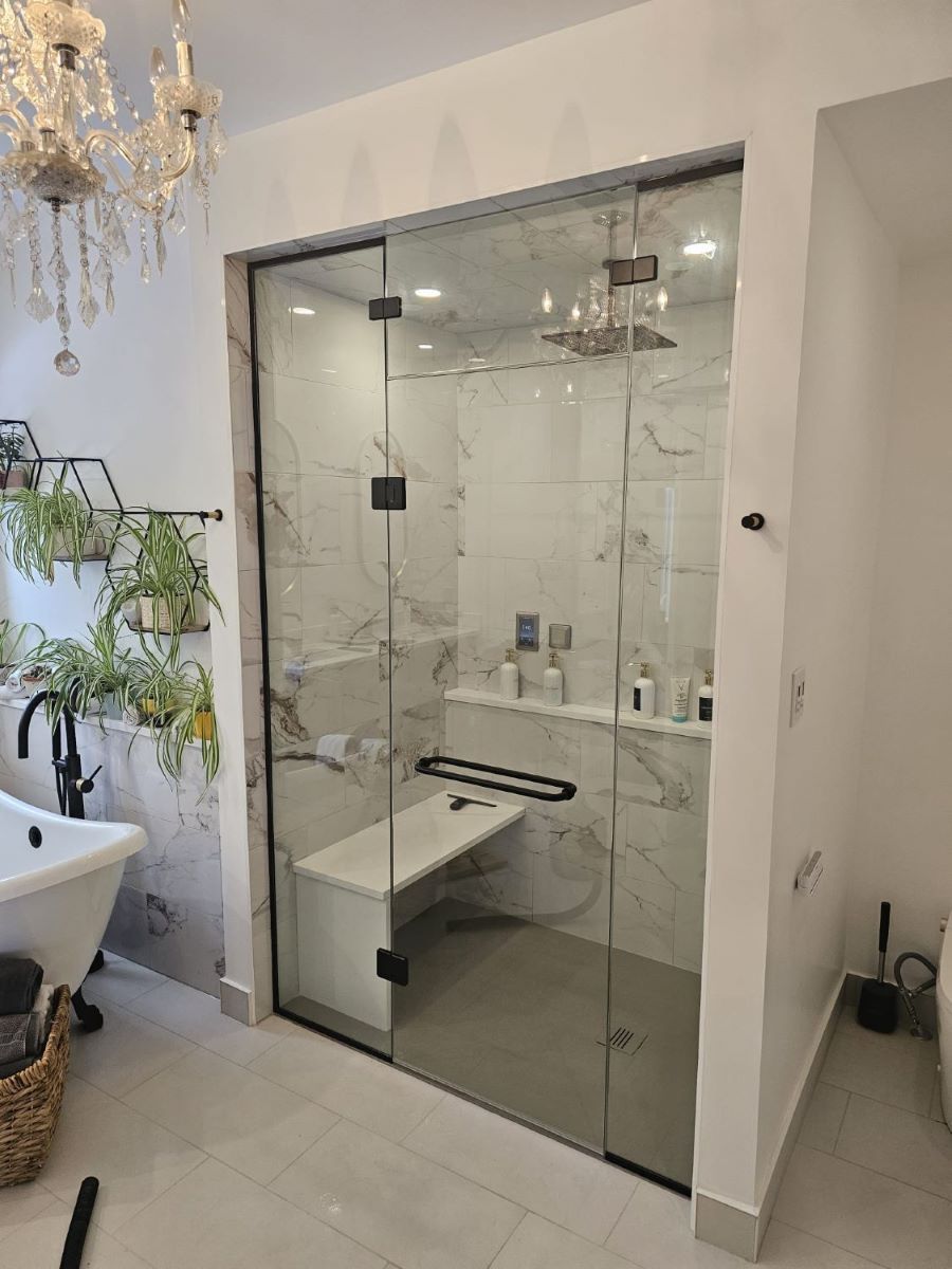 custom glass steam shower with matte black hardware and double sided towel bar
