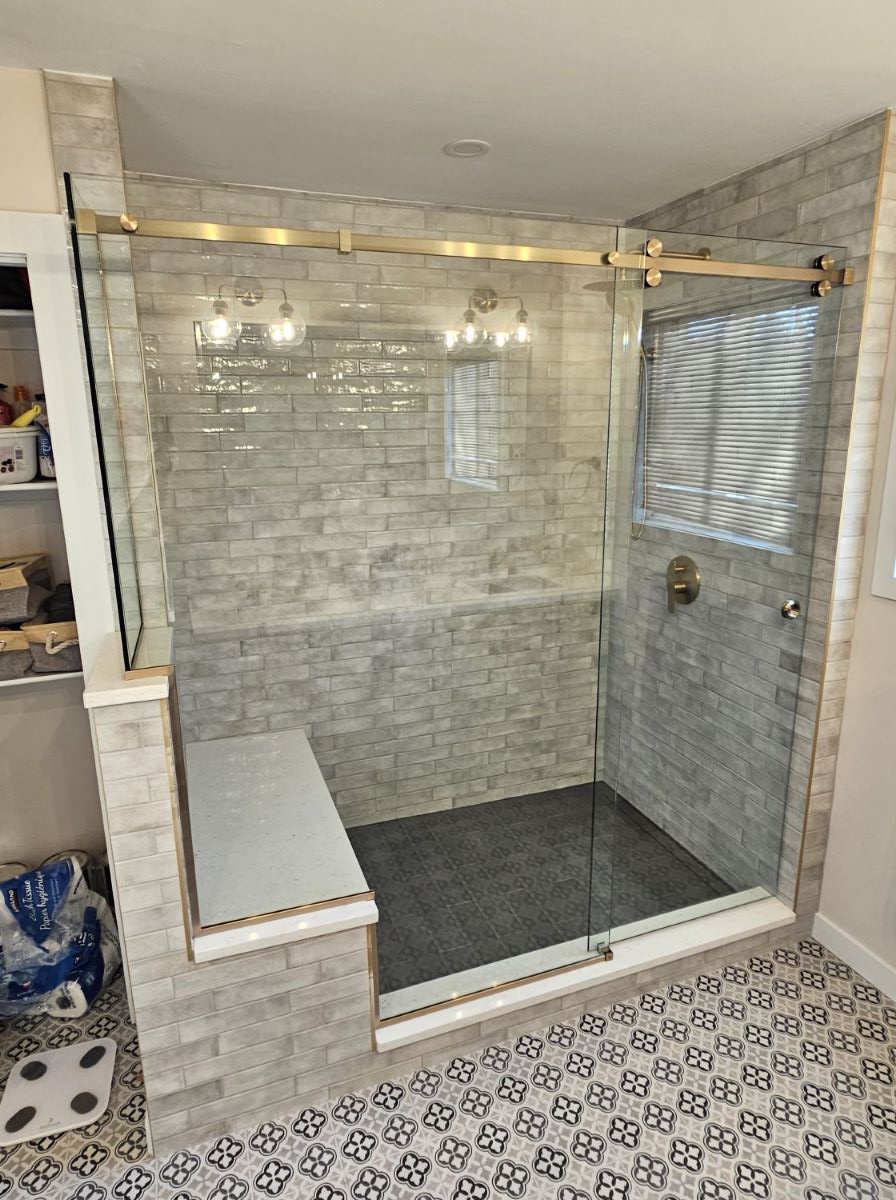 custom glass shower with sliding door and satin brass hardware