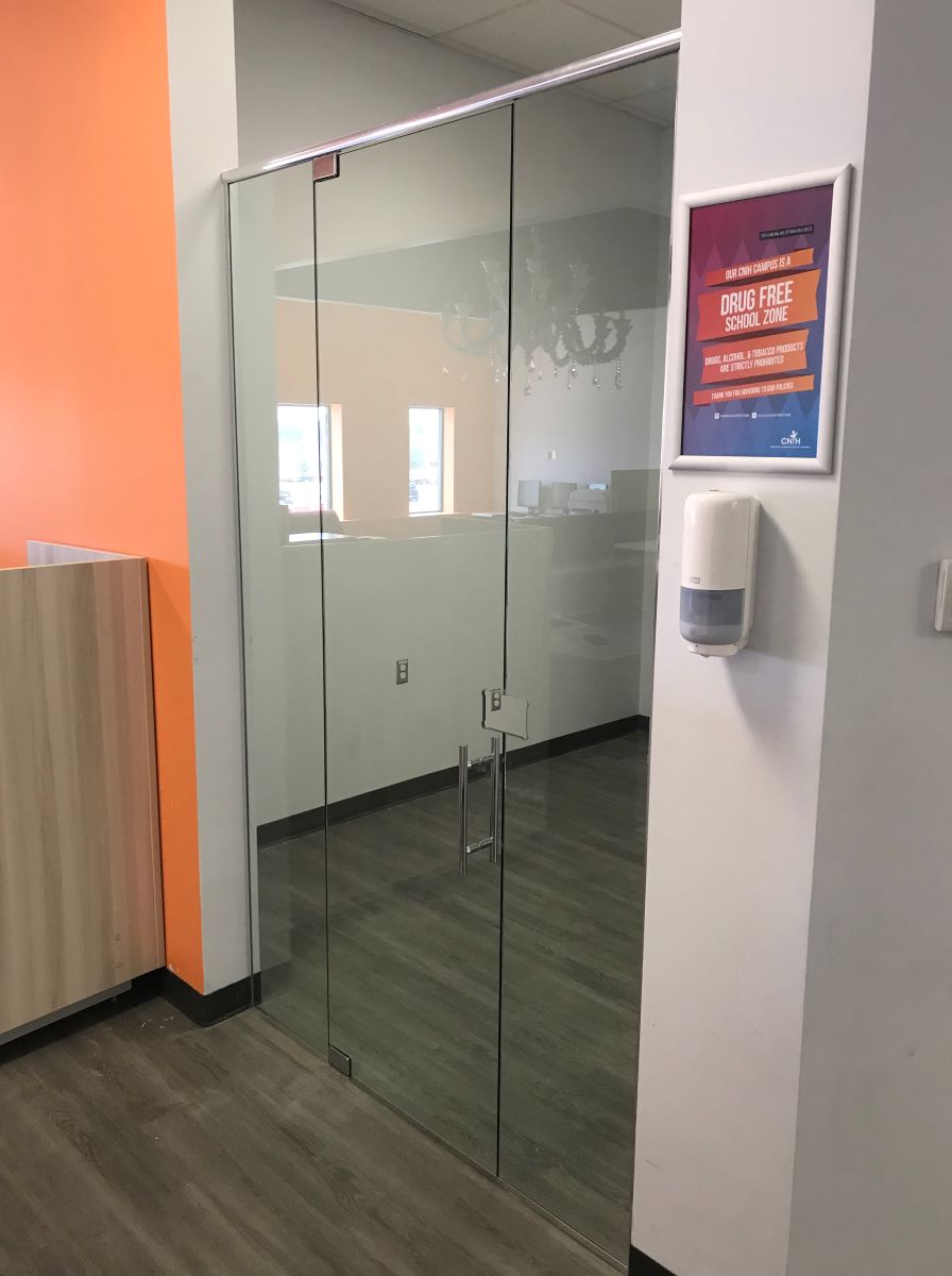 one pivot door glass office with header and chrome hardware and ladder pull handle 
