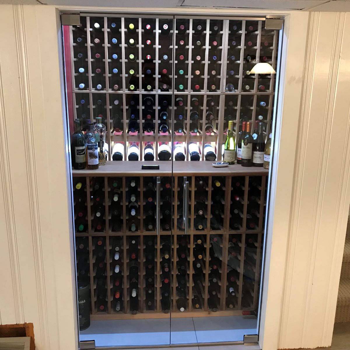 two door glass wine cellar with brushed nickle hardware and ladder pull handles  