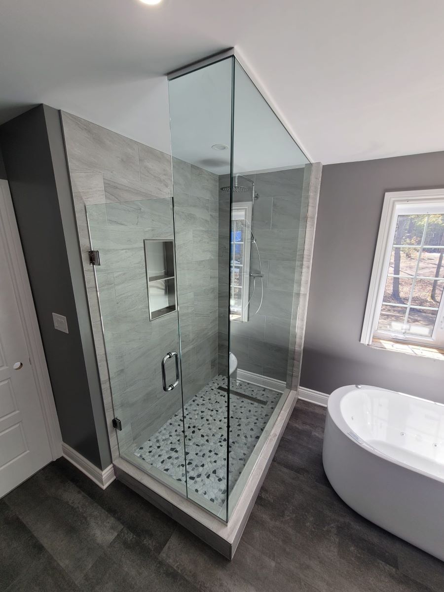 custom glass shower with floor to ceiling glass and a wall mounted door 