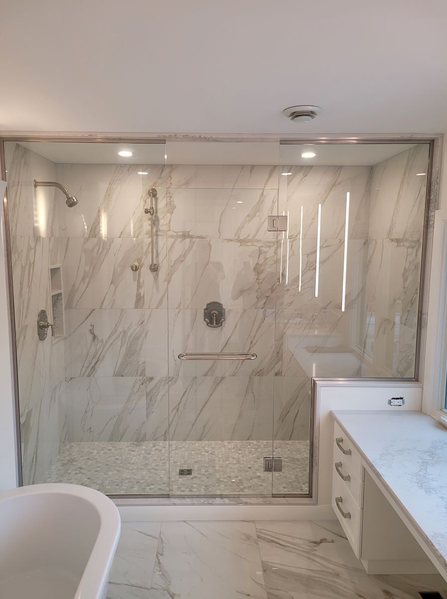 custom glass shower with floor to ceiling glass and brushed nickel hardware with double towel bar handle 
