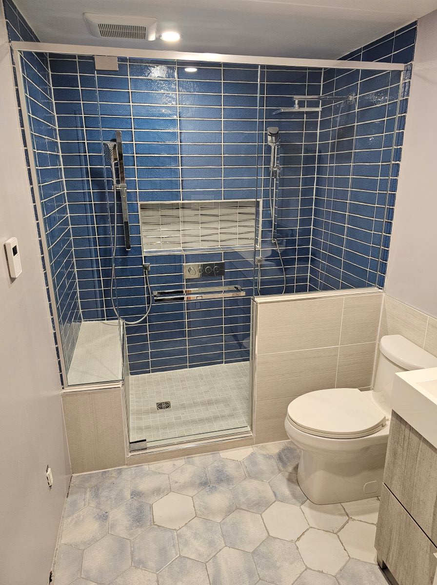 custom glass shower with 2 knee walls and chrome header pivot door with a square double towel bar