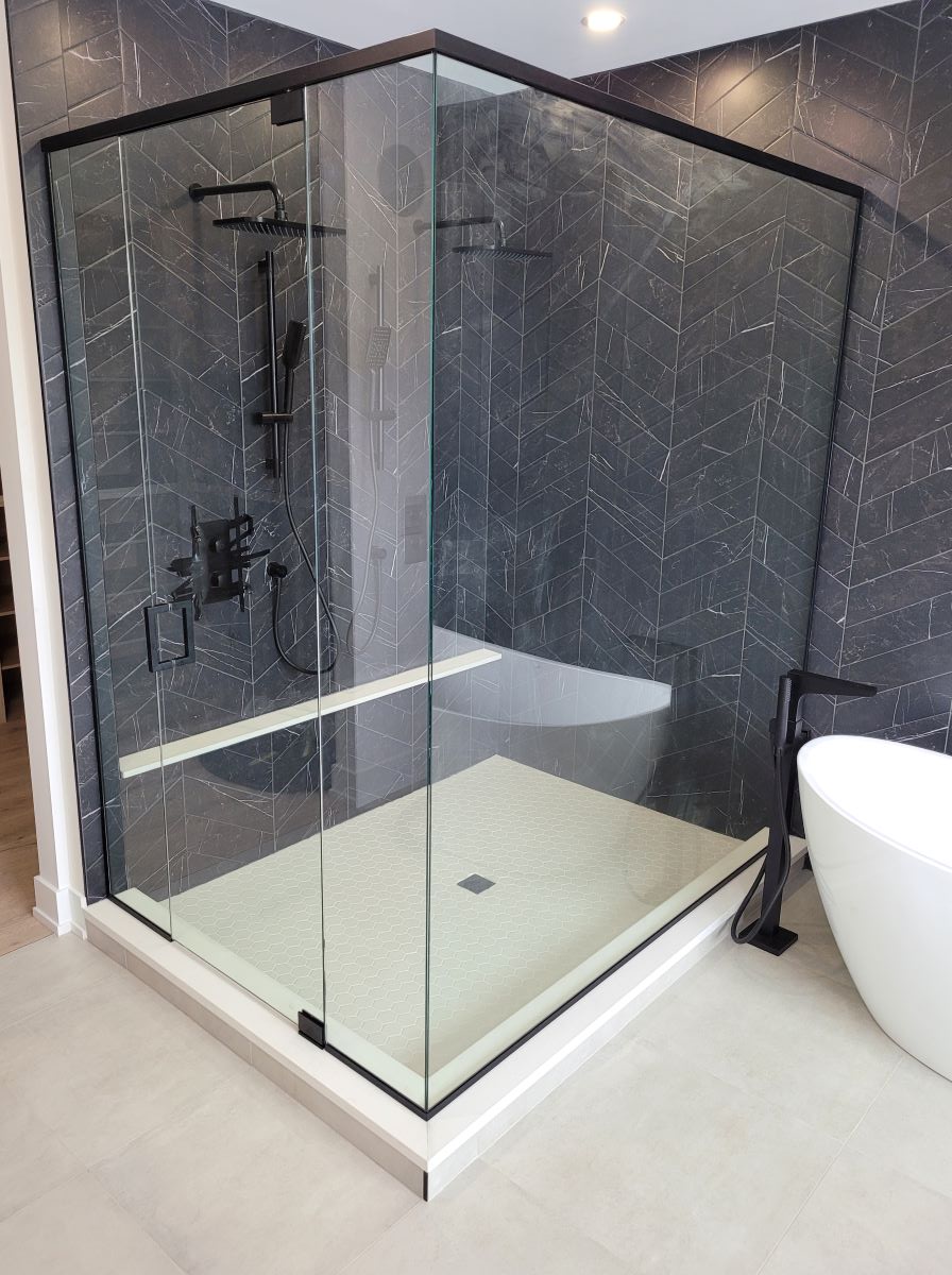 custom glass shower with header and pivot door and a square handle 