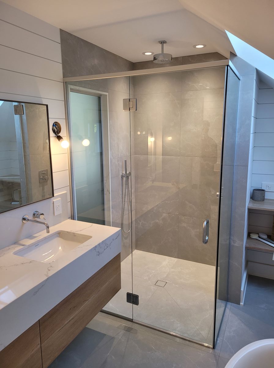 custom glass shower with a side panel and chrome glass hinged hardware and header