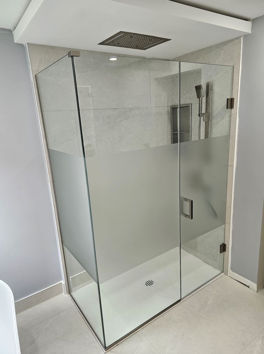 custom glass shower with privacy film installed on the middle of the glass and brushed nickel square hardware 